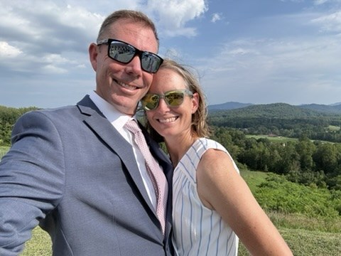 Josh Thompson and his wife, Amy, outdoors with mountains behind them